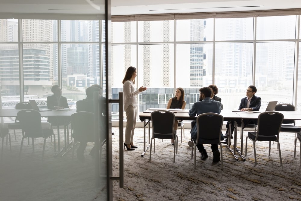 Wide,Shot,Of,Multiethnic,Business,Team,Talking,At,Meeting,Table